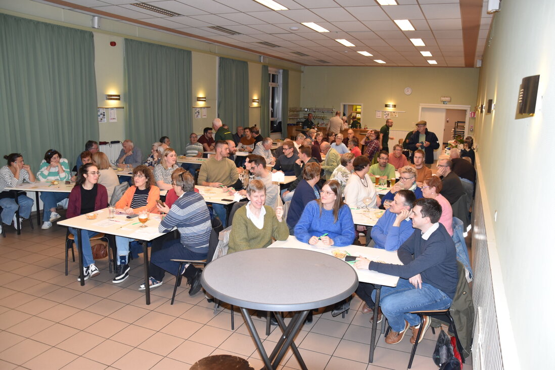 Teams aan lange tafels tijdens de quizavond 2024